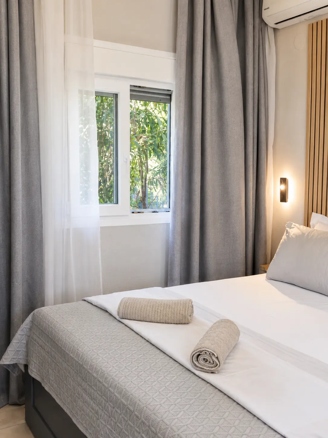 Rolled towels on the bed in the bright bedroom