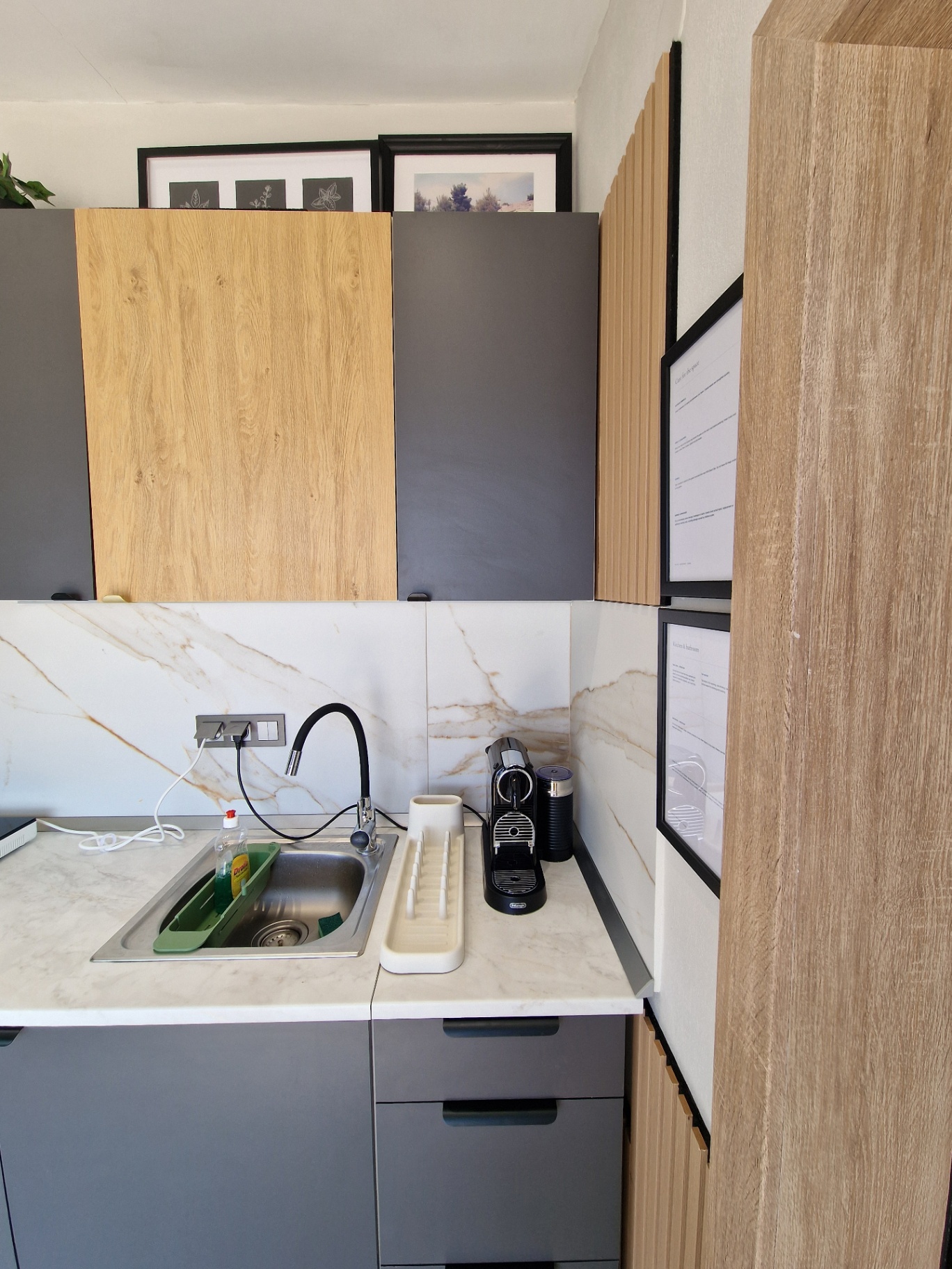 Kitchenette sink, drying rack and espresso machine under timber cabinets