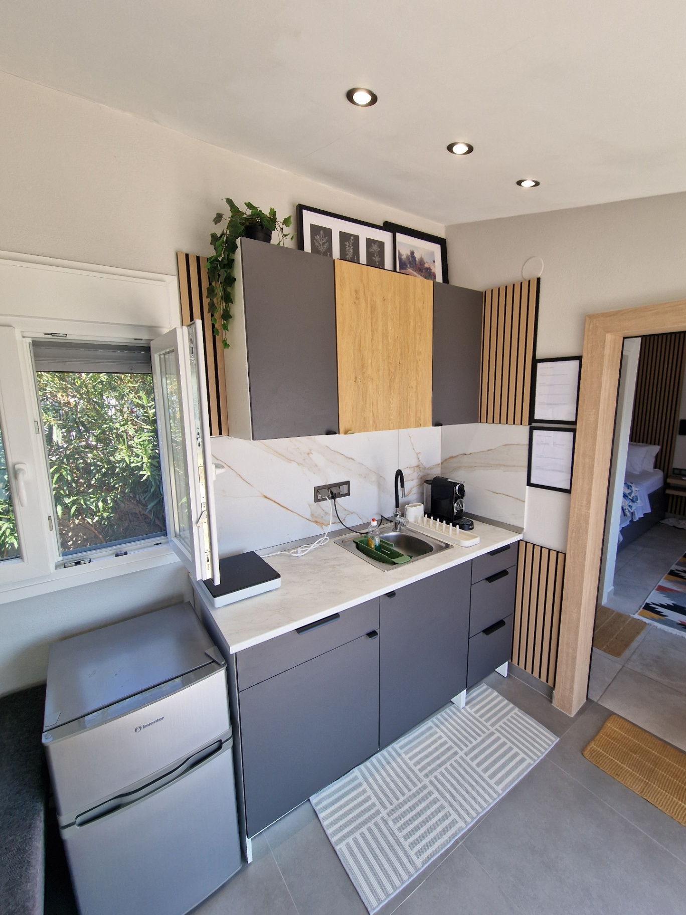 Kitchenette counter, fridge and the open window onto the garden