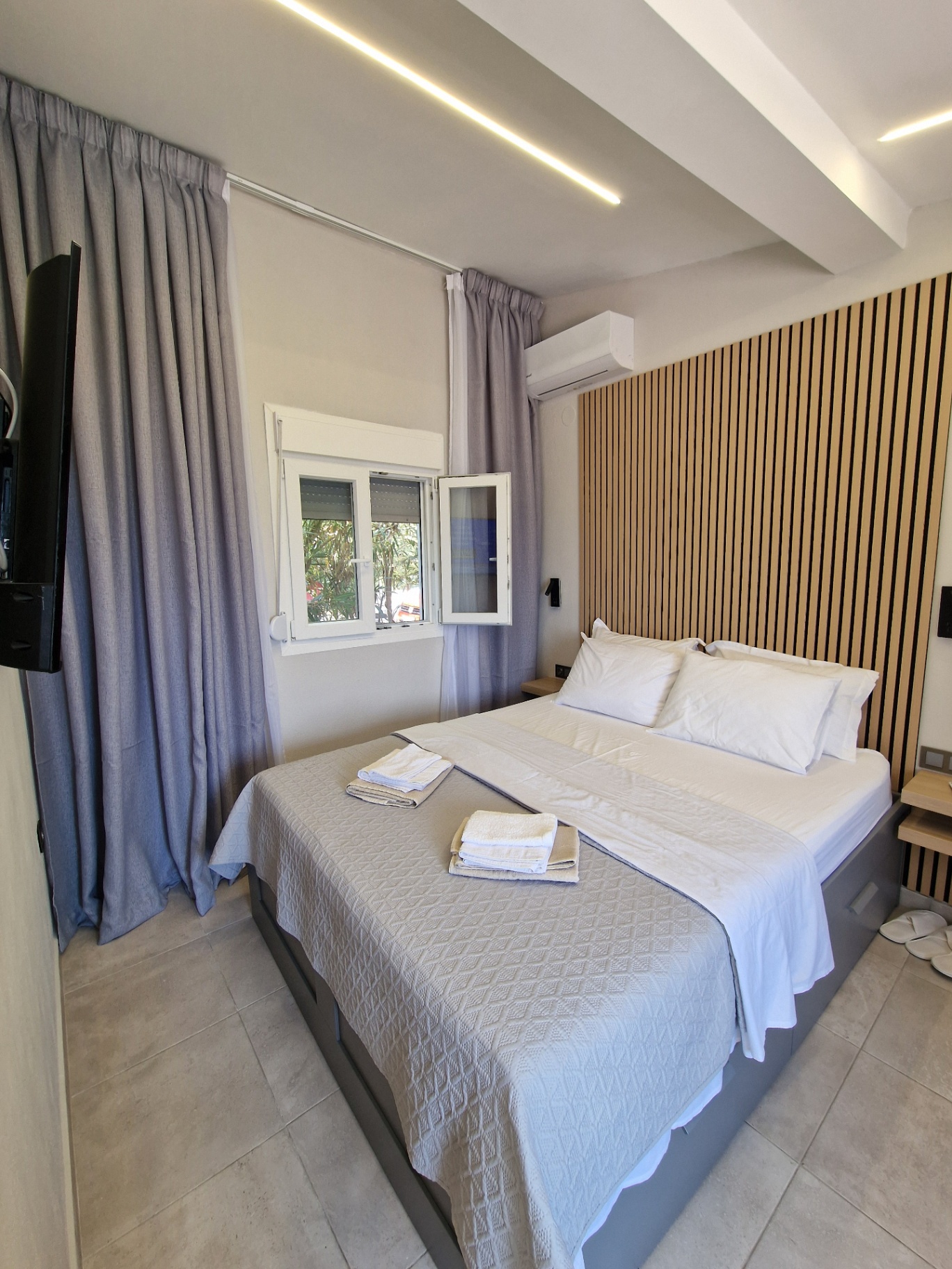 Double bed with timber slat headboard and fresh linens at SEA La Vie Studio