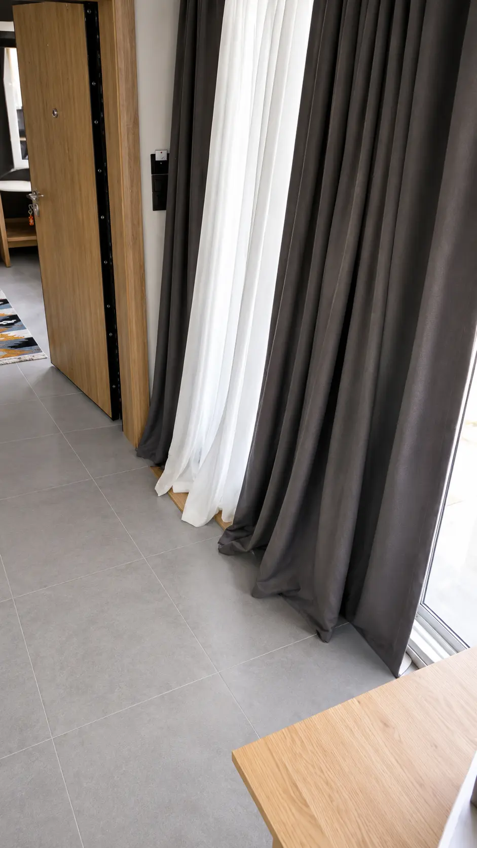 Charcoal and sheer curtains falling to the tiled floor