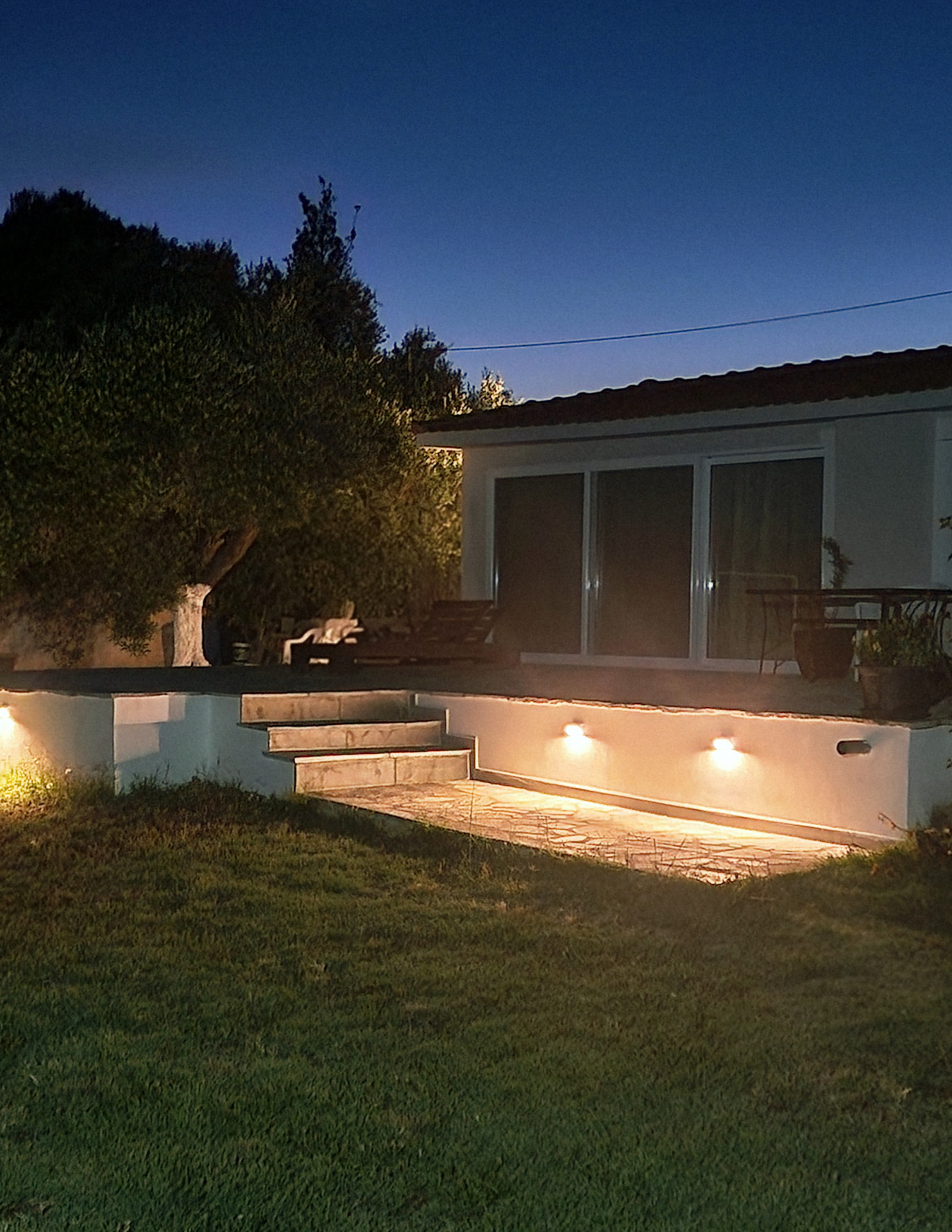 Warm step lighting on the stone terrace after dark