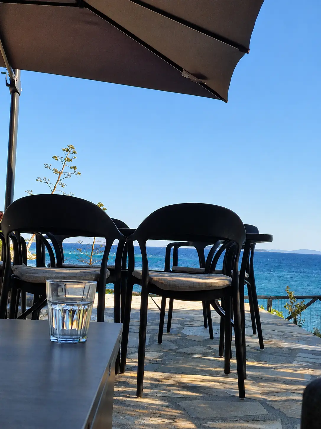 Shaded terrace table looking out over the Aegean Sea at Kalogria Beach