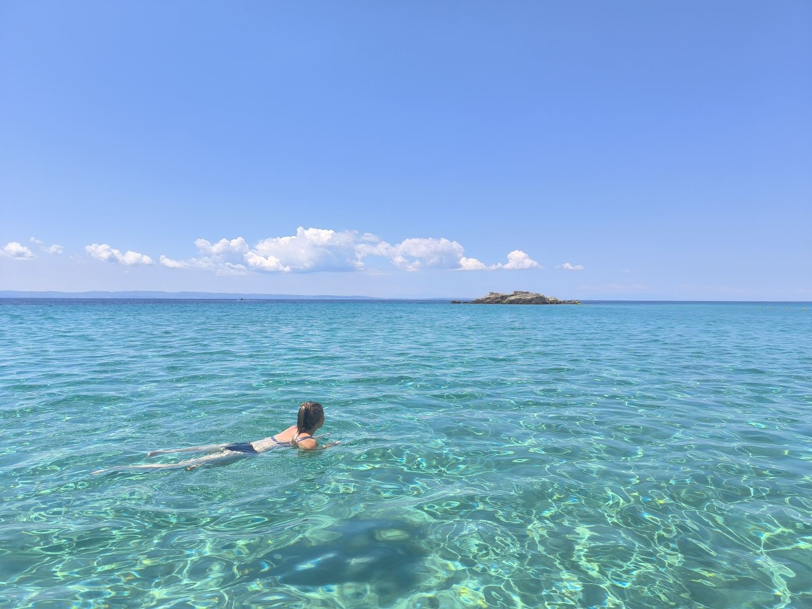 Swimmer in the clear turquoise water at Kalogria Beach, Sithonia