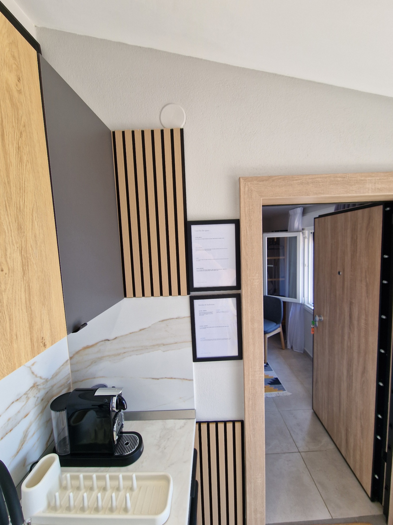 Coffee corner with espresso machine, marble backsplash and slatted timber panels