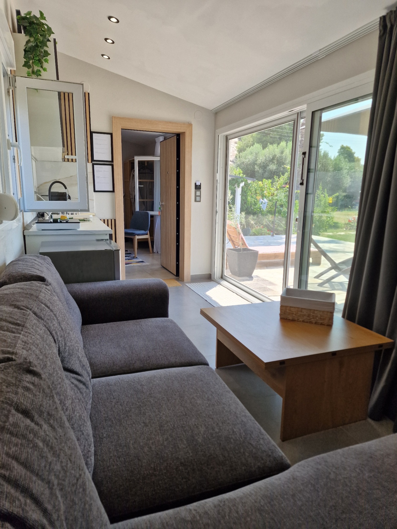 Living area looking out through the glass doors to the sunlit terrace