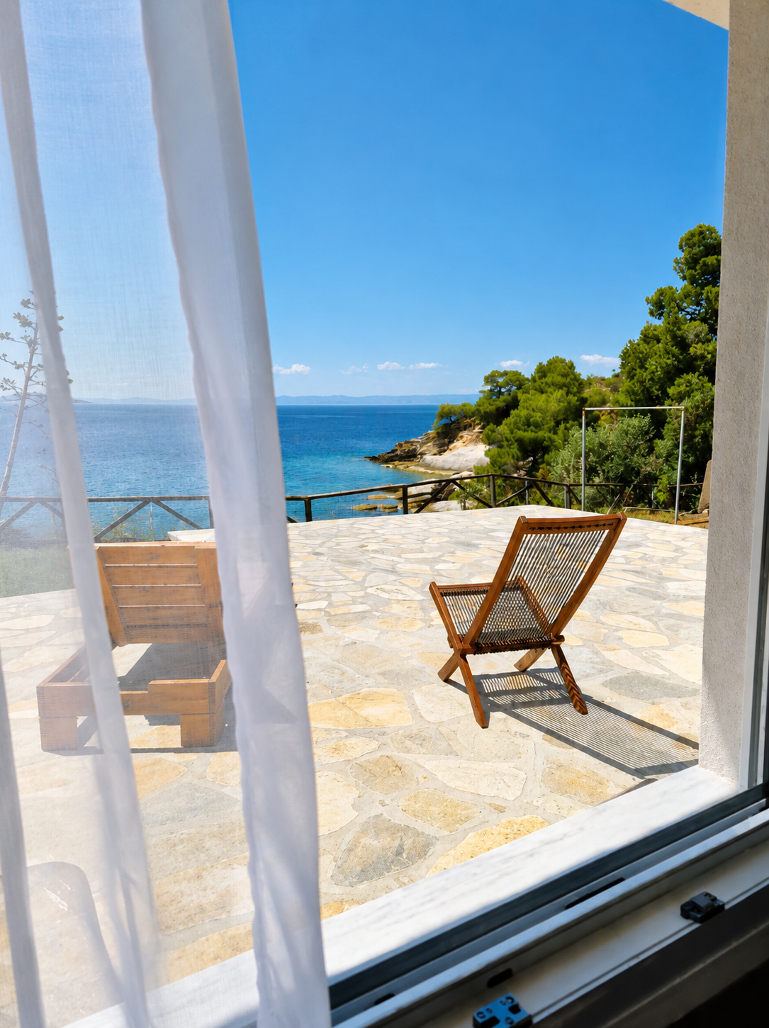 Sea terrace seen through soft curtains from inside the studio
